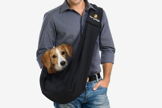 Man carrying a dog in the FurryFido Pet Sling.